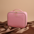 Pink textured travel bag with gold accents on a light purple background